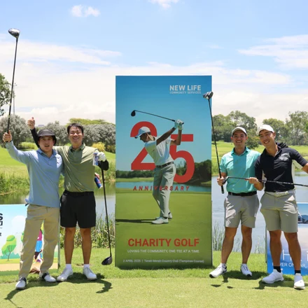 Golfers with the 25th anniversary Charity Golf banner